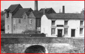 Coton Mill seen from the bridge, with its chimney behind.