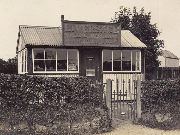 Liversage general merchant&rsquo;s shop, with large windows, seen through gates.