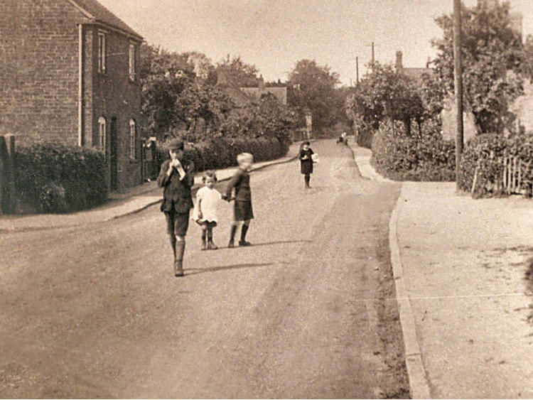 Sepia view along the road with children and a horse.