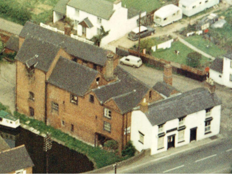 Aerial view of cottages strung along the road.