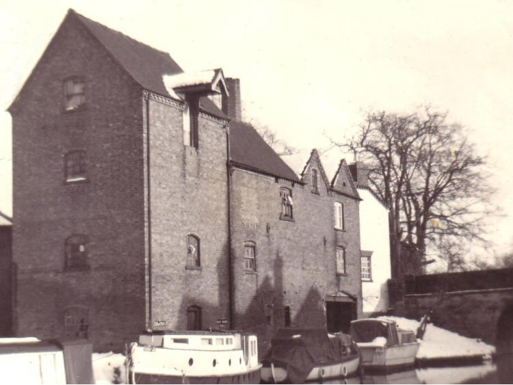 The tall mill building with narrowboats moored below.