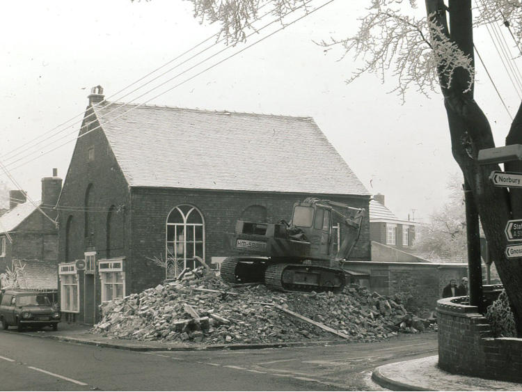 A chapel part demolished, rubble in the foreground.