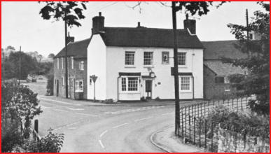 The Royal Oak, a white rendered public house on the corner, with railings.